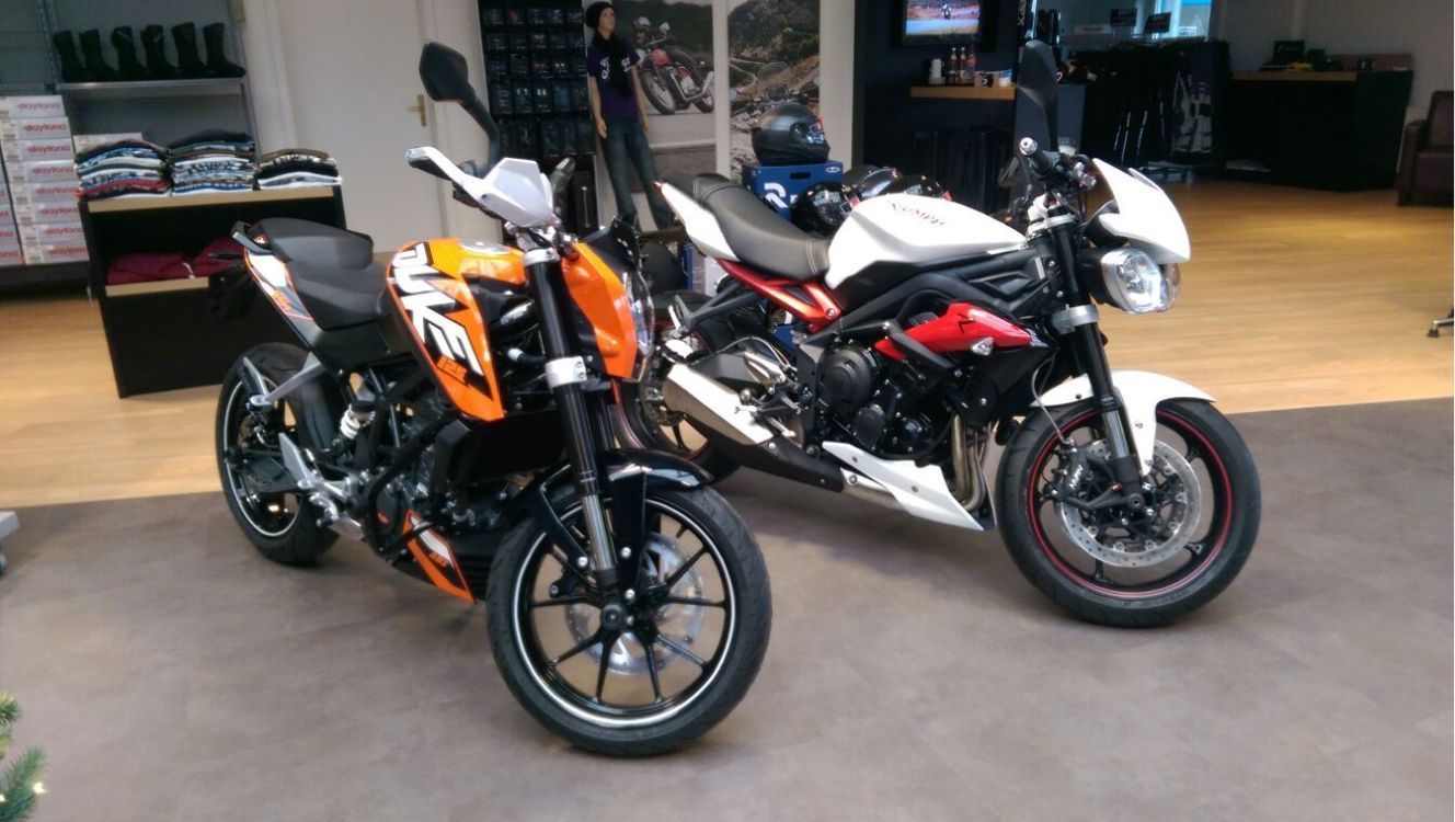 Zwei Motorräder sind nebeneinander in einem Raum geparkt