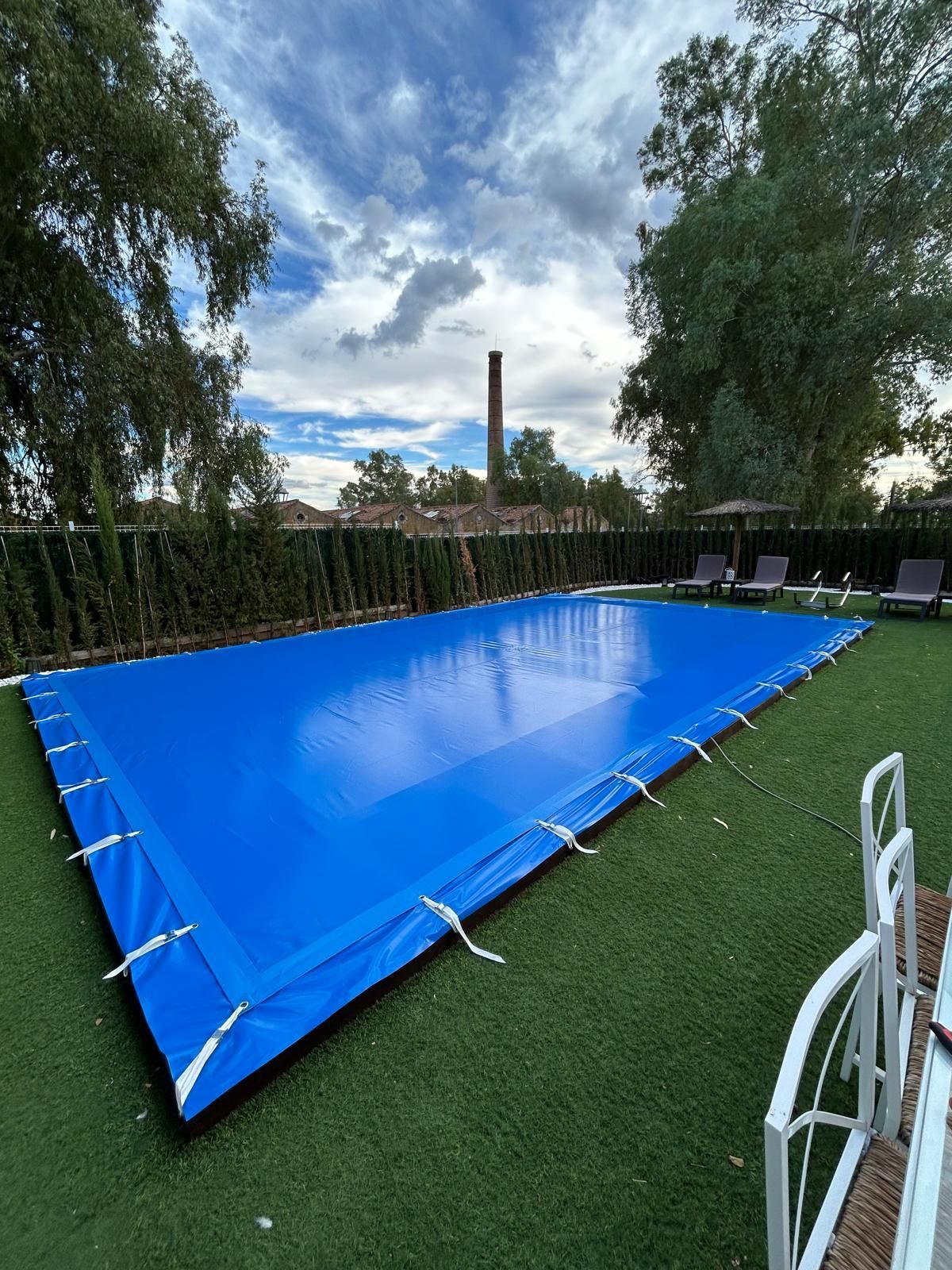Un patio con mesa y sillas bajo un techo de cristal.