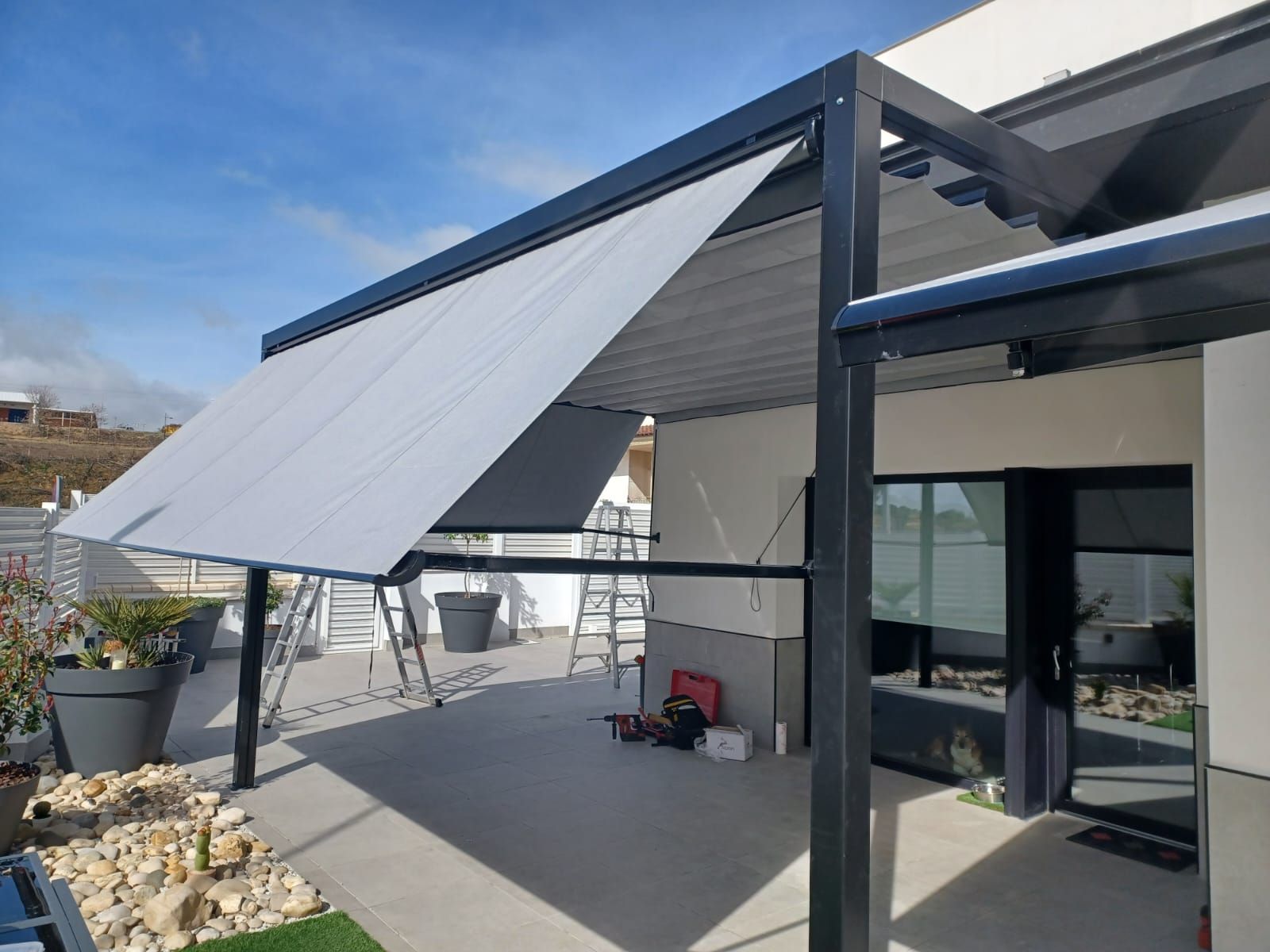 Un patio con una mesa y sillas bajo una pérgola.