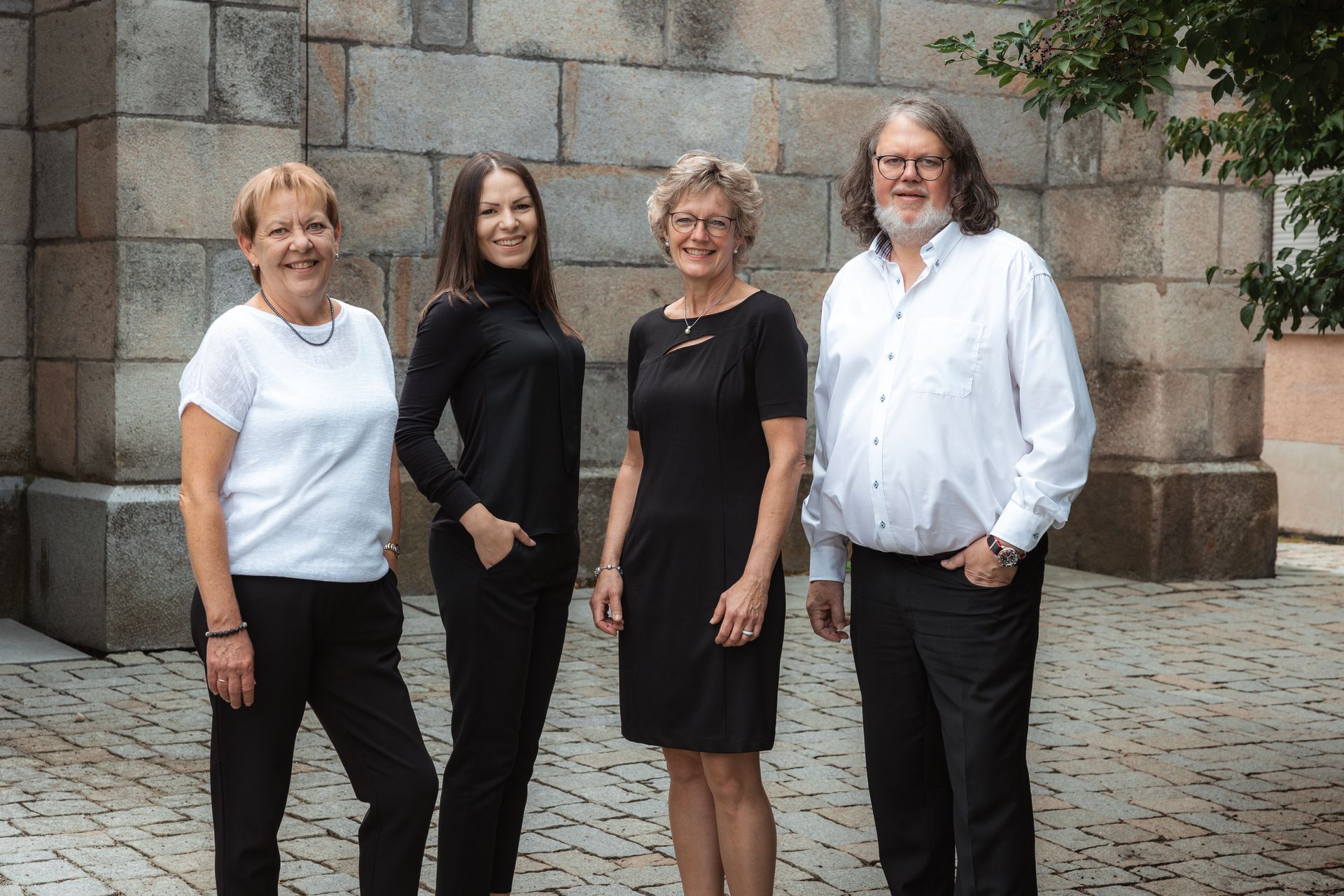 Team Rechtsanwälte Reinhold J. Korbl Das Team von Rechtsanwälte Reinhold J. Korbl steht nebeneinander vor einer Steinmauer und lächelt in die Kamera