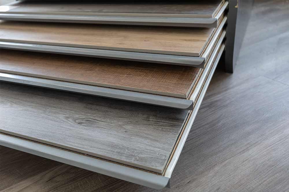 Stapel von Laminatdielen in Holzoptik in Grau- und Brauntönen