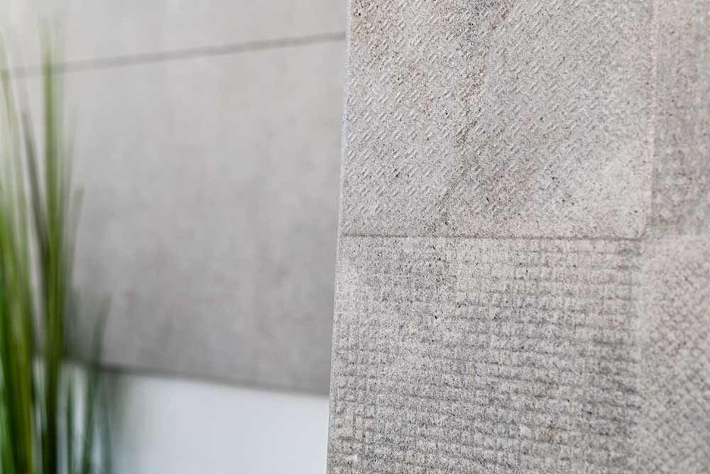 Steinmauer mit einer kleinen eingelassenen Tafel mit eingraviertem Text und verschwommenem grünem Gras im Vordergrund
