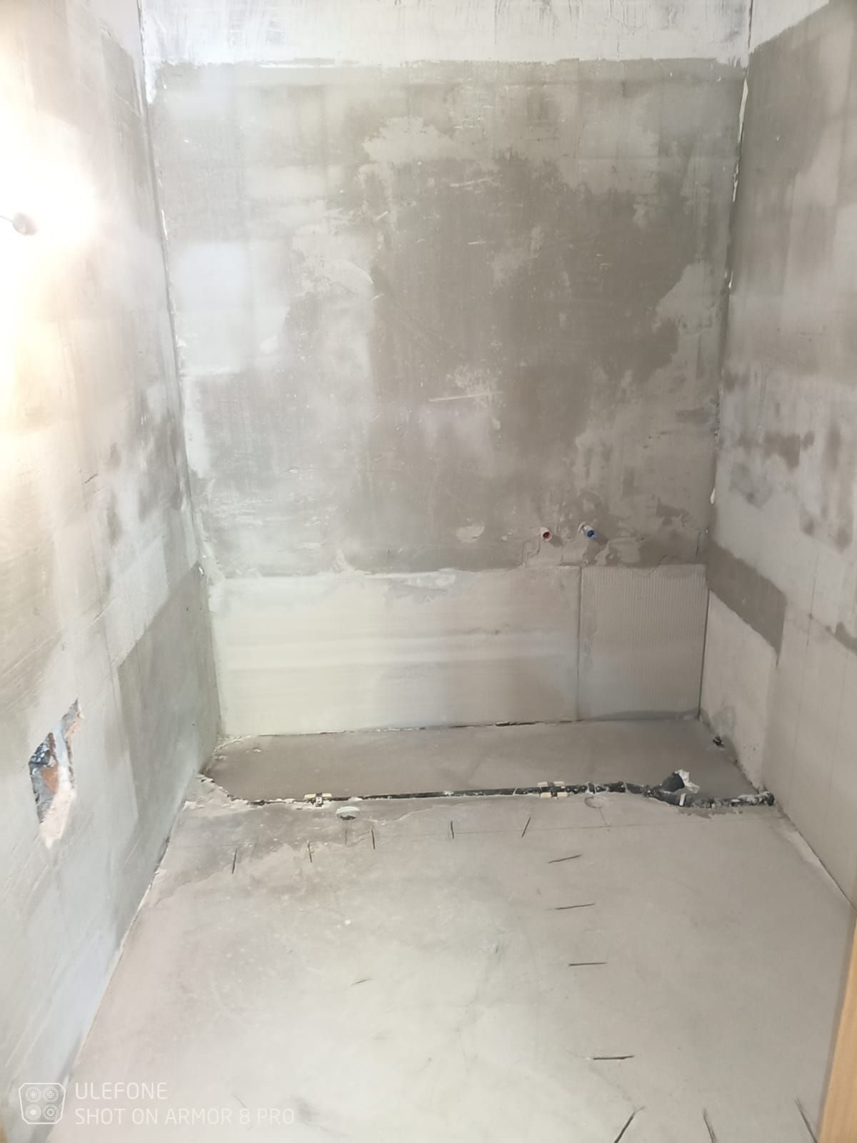 Ein im Bau befindliches Badezimmer ohne Fliesen auf dem Boden und an den Wänden.