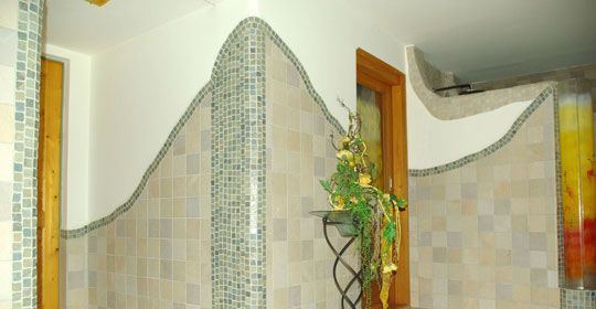 Ein Badezimmer mit ebenerdiger Dusche und Buntglasfenster.