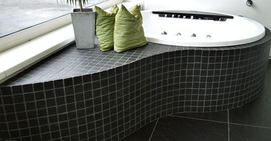 Ein Badezimmer mit Whirlpool und grünen Kissen