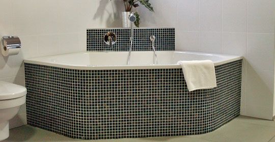Eine Badewanne in einem Badezimmer neben einer Toilette