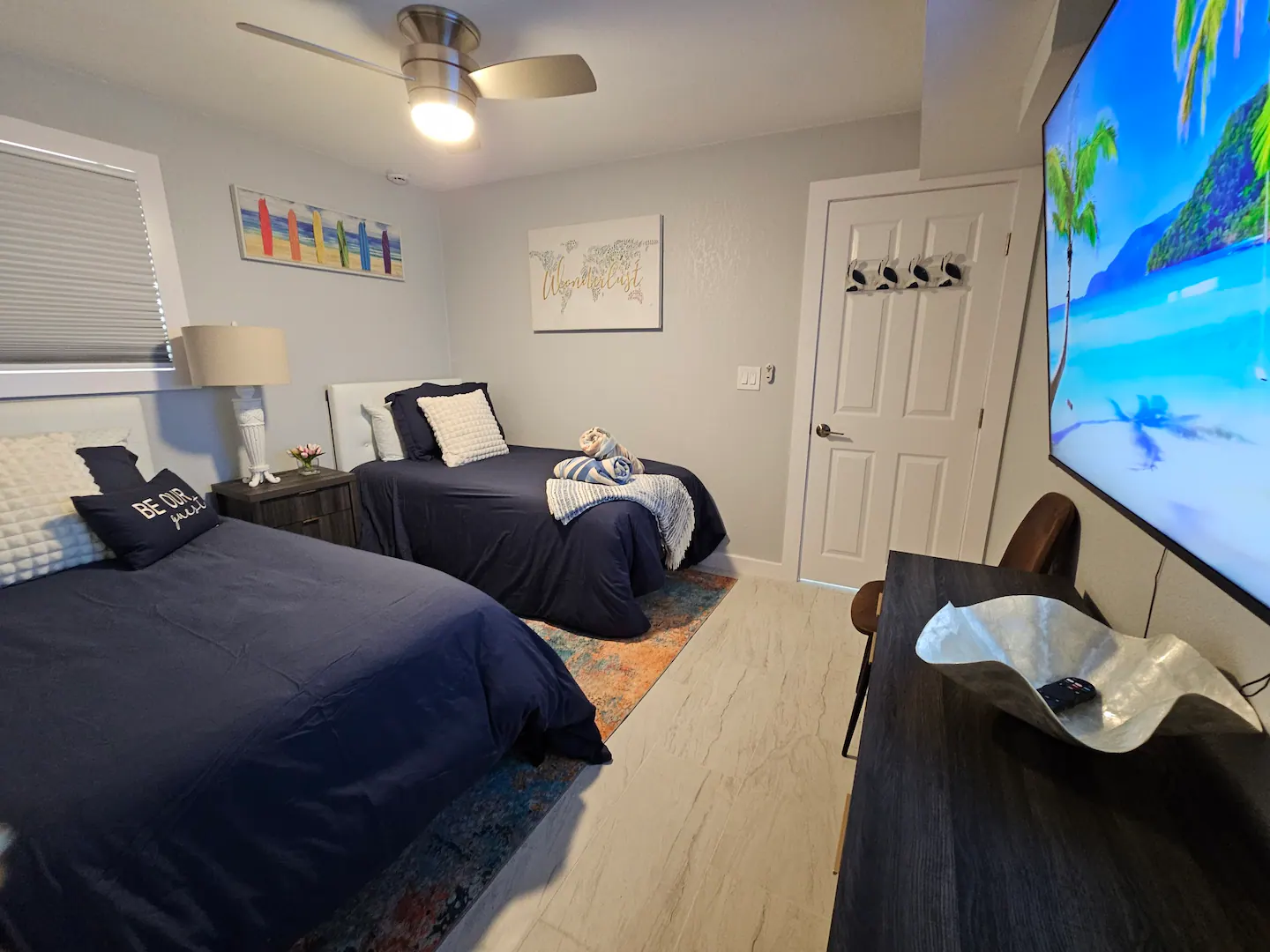 A bedroom with two beds and a flat screen tv.