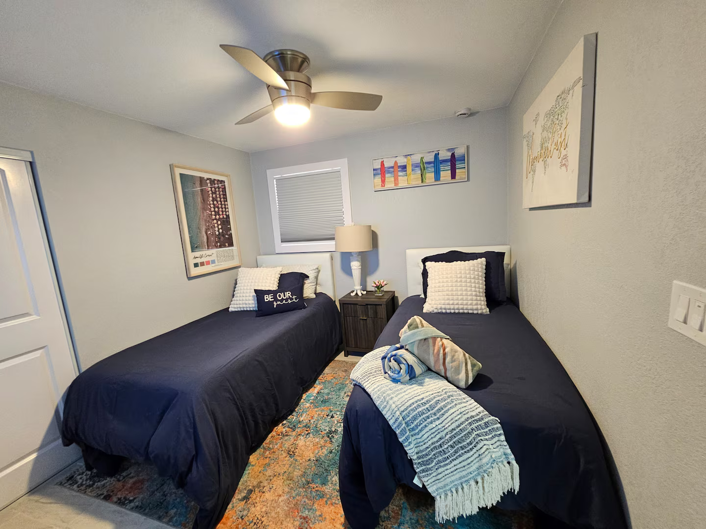 A bedroom with two twin beds and a ceiling fan.