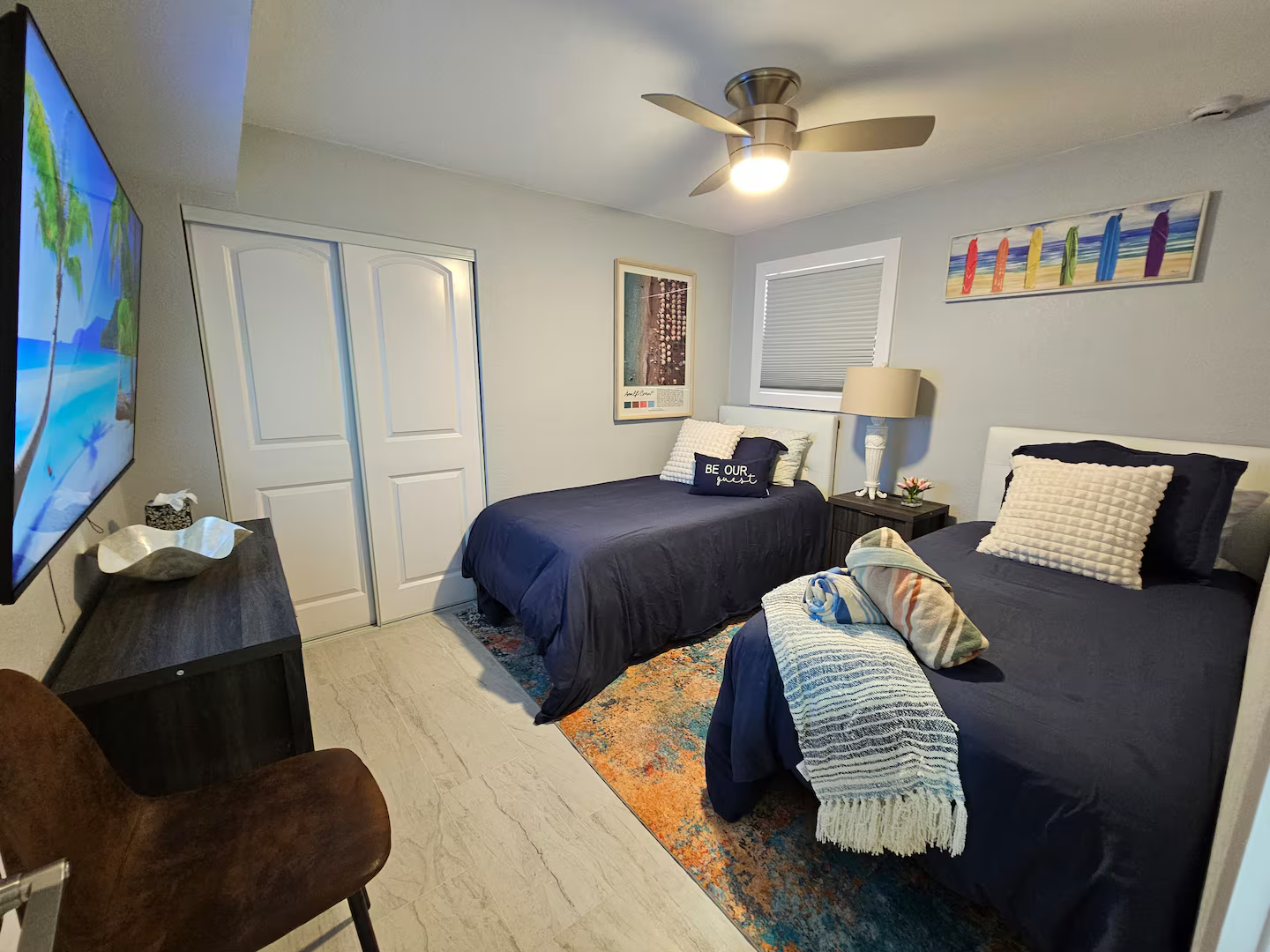 A bedroom with two beds and a flat screen tv.