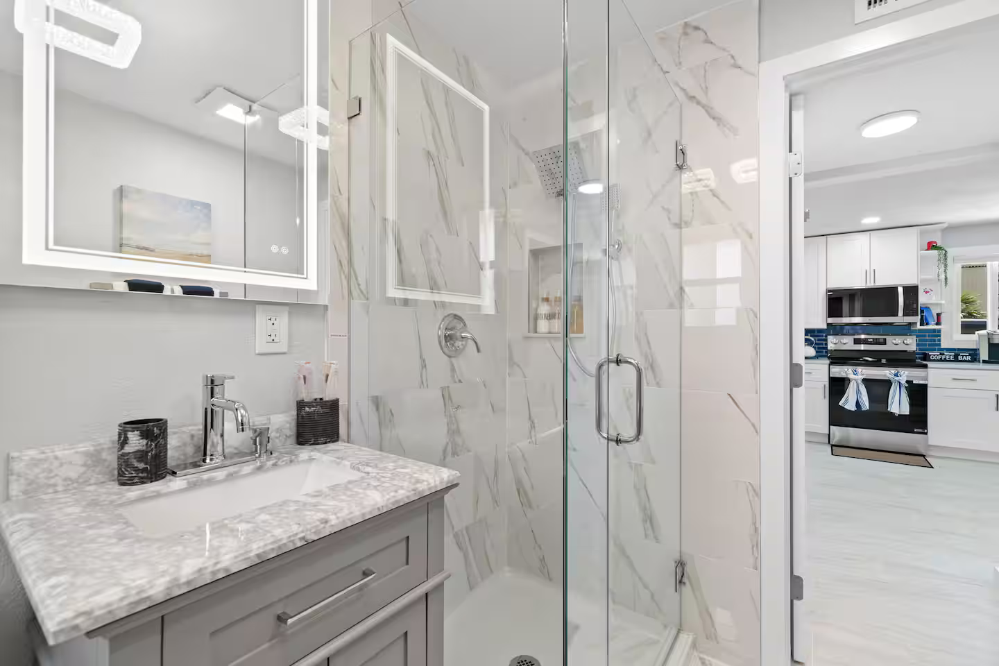 A bathroom with a sink , mirror and walk in shower.