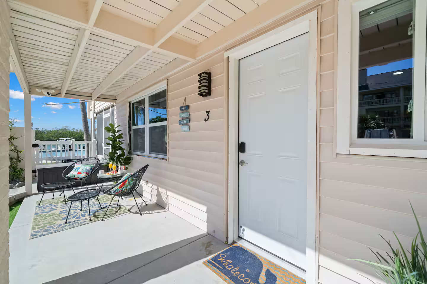 There is a porch with a table and chairs on it.