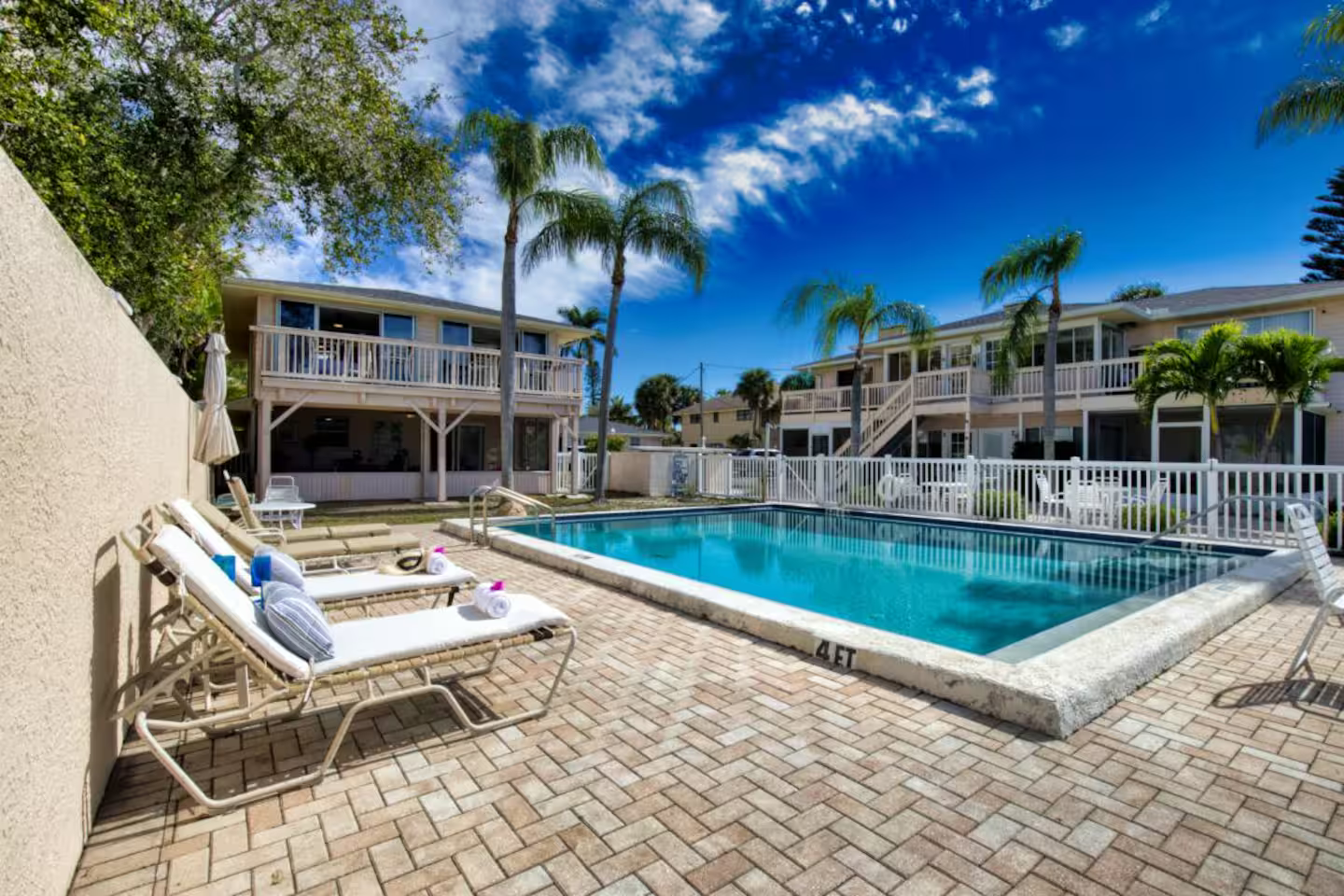 A large swimming pool in front of a building with palm trees