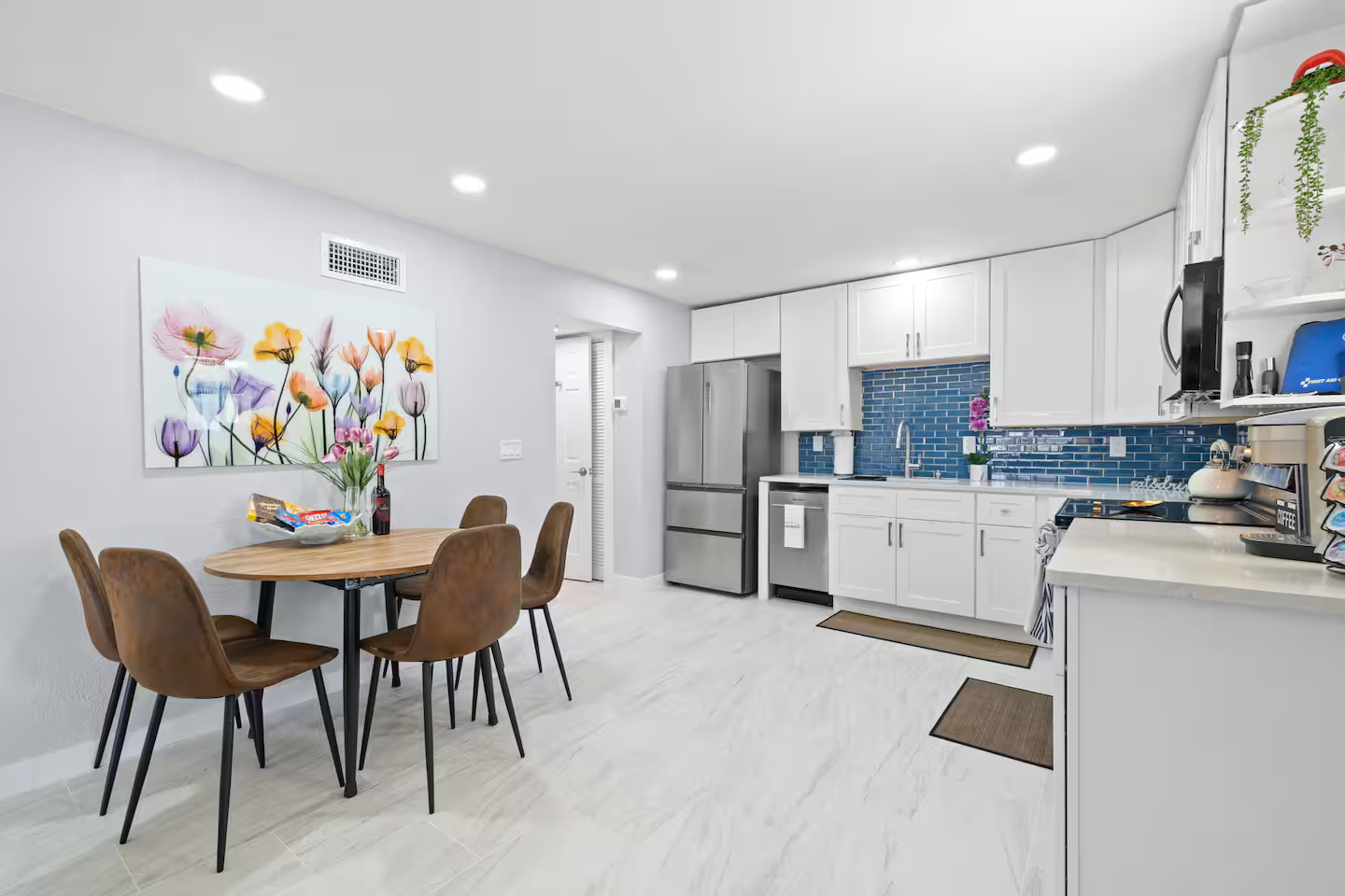 A kitchen with a table and chairs and a refrigerator.