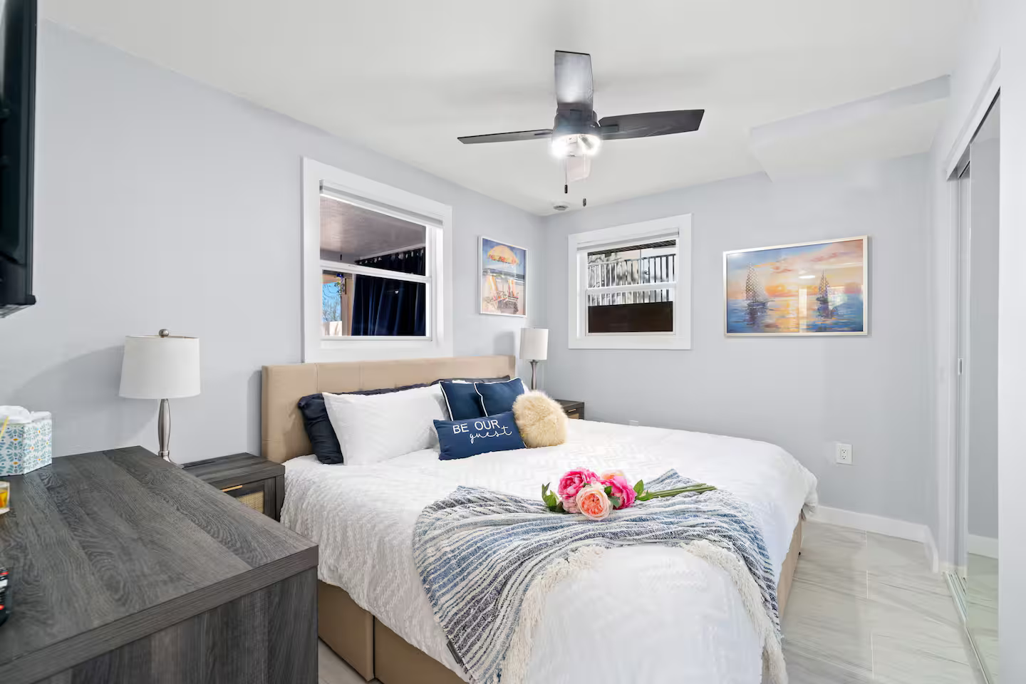 A bedroom with a king size bed and a ceiling fan.