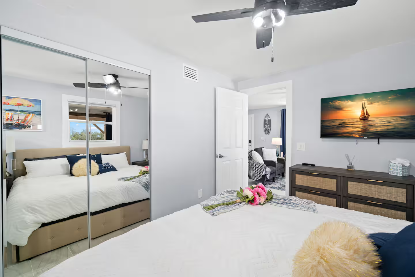 A bedroom with a large bed and a ceiling fan.