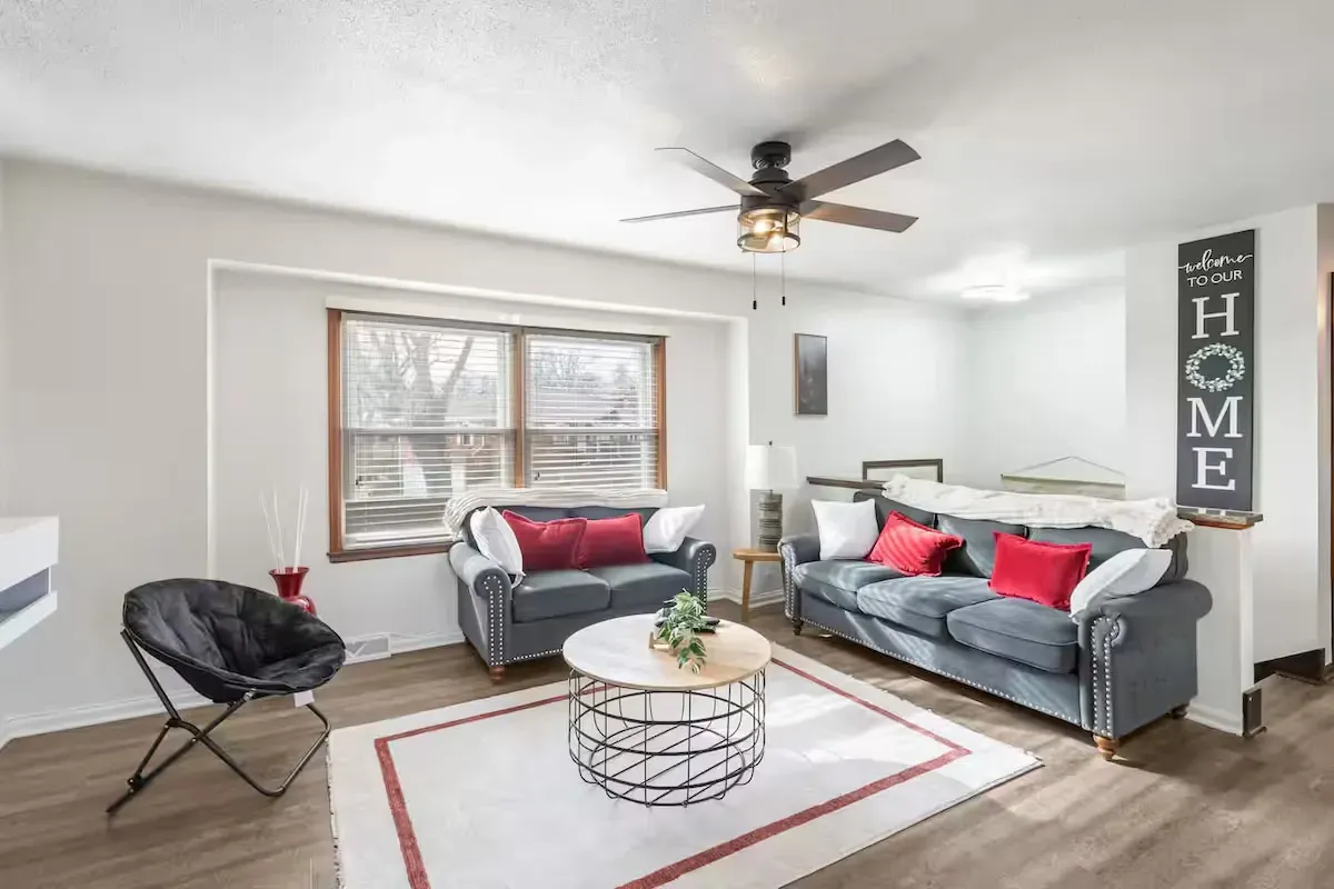 A living room with two couches, a coffee table, and a ceiling fan.