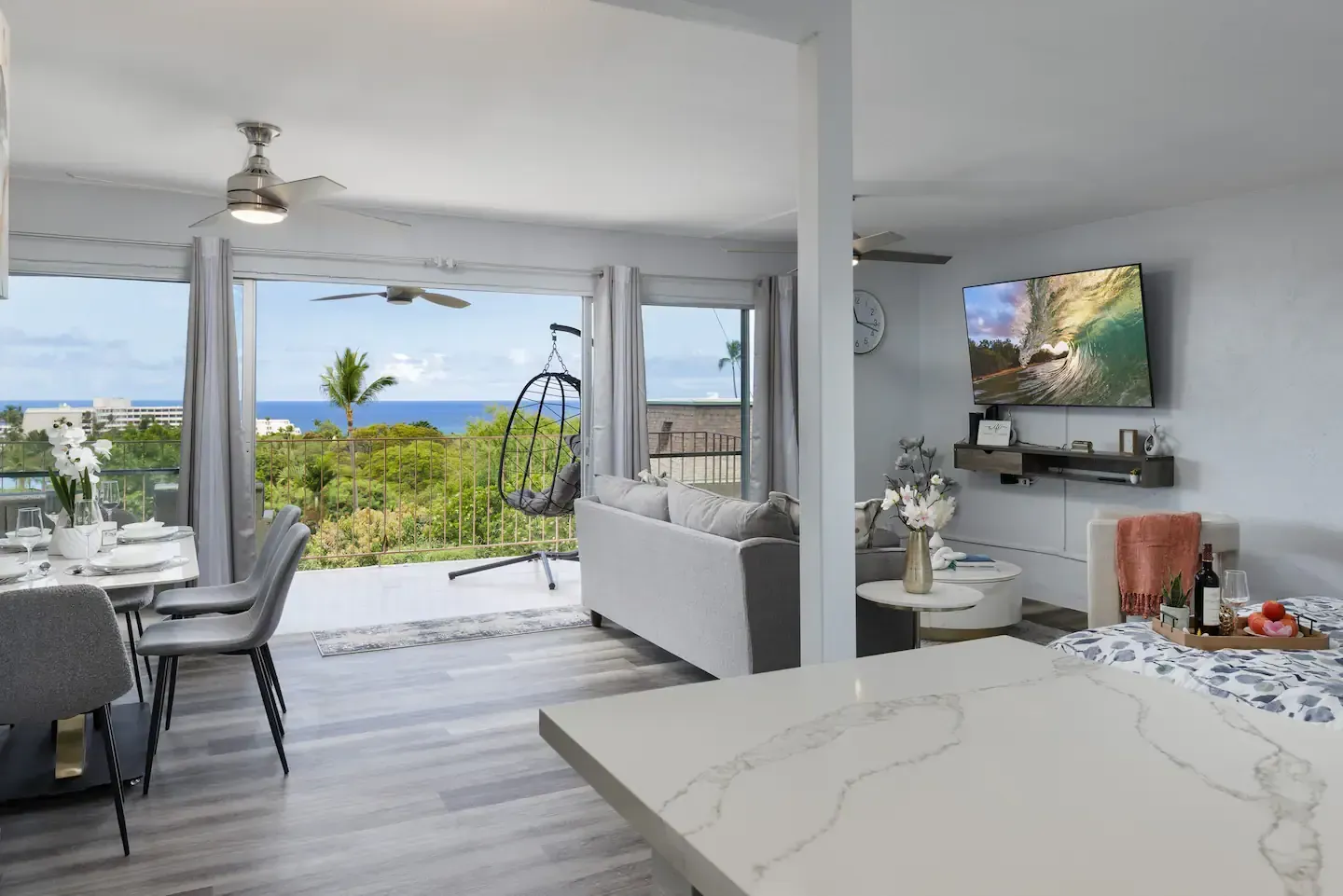 A living room and dining room with a view of the ocean.