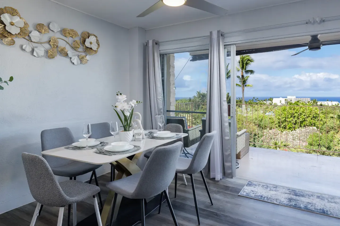 A dining room with a table and chairs and a view of the ocean.