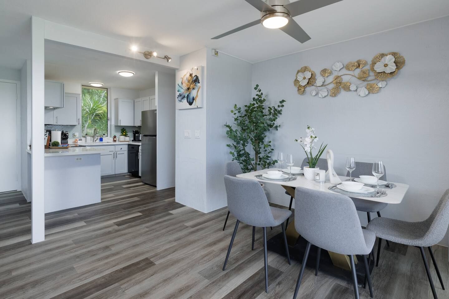 A dining room with a table and chairs and a ceiling fan.