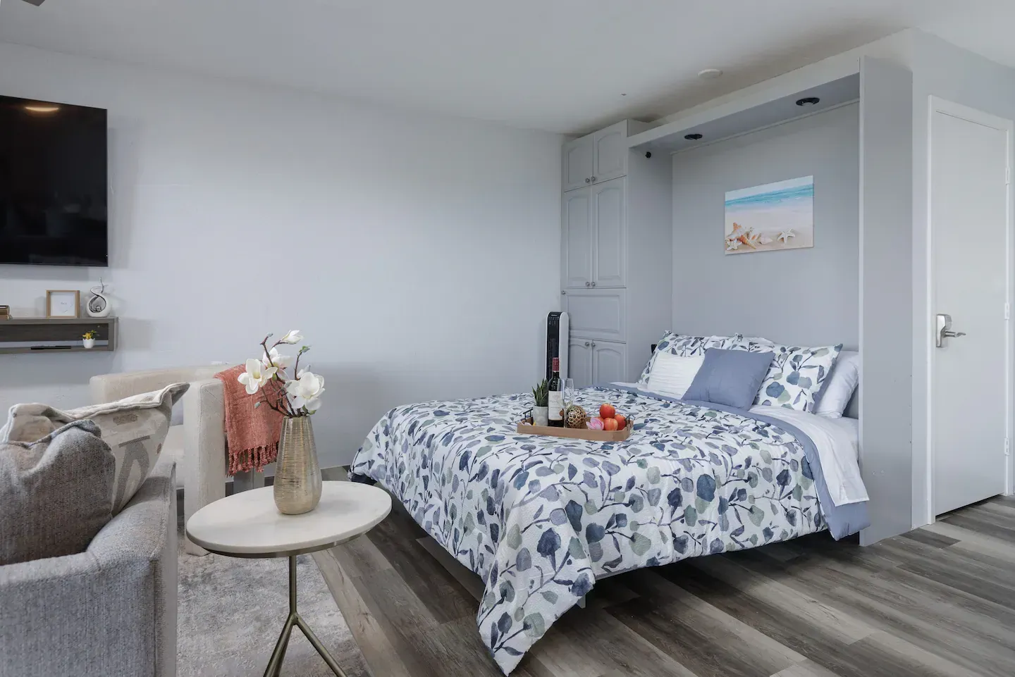 A bedroom with a bed , couch , table and television.