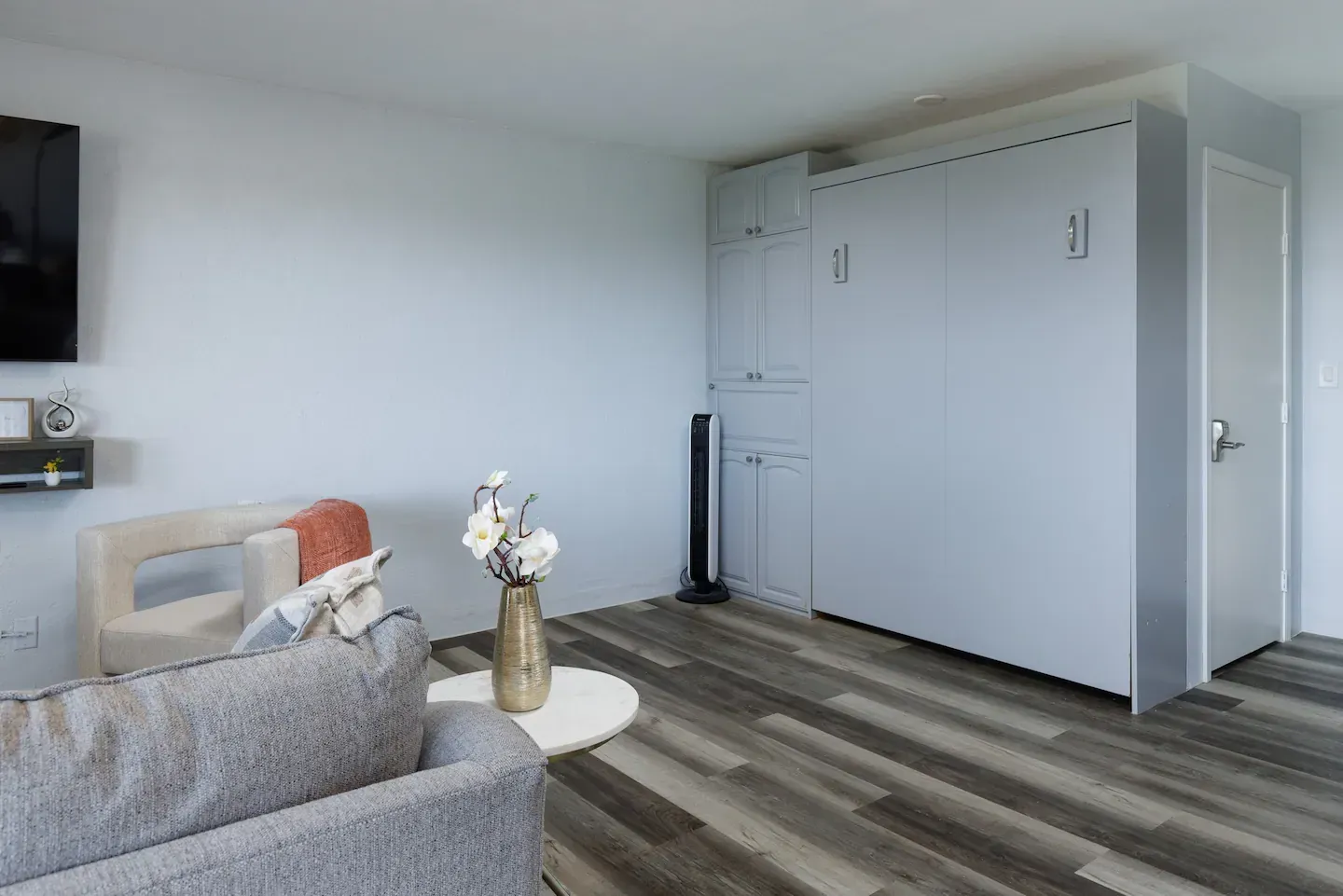 A living room with a couch , chair , and television.