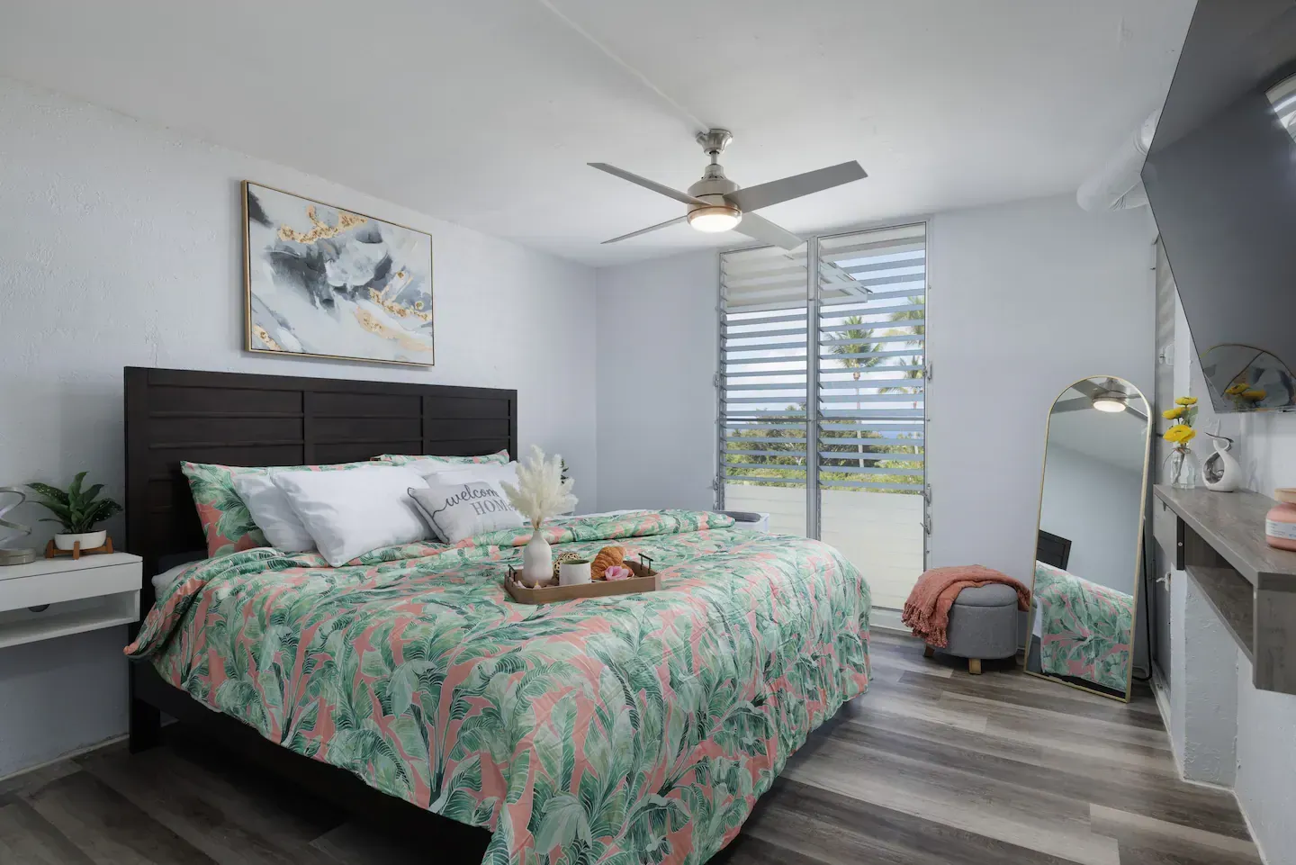 A bedroom with a large bed and a ceiling fan.