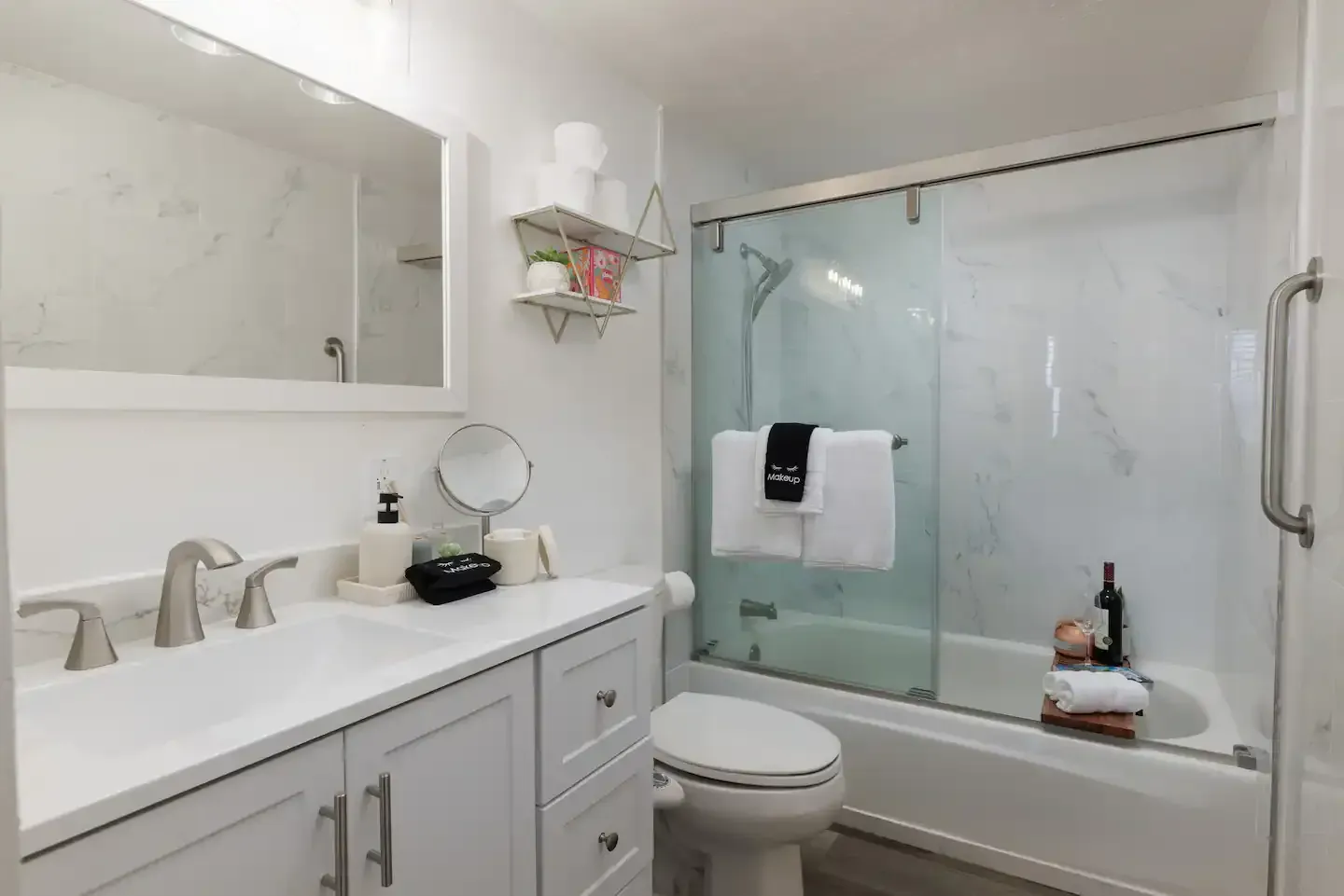 A bathroom with a toilet , sink , mirror and bathtub.