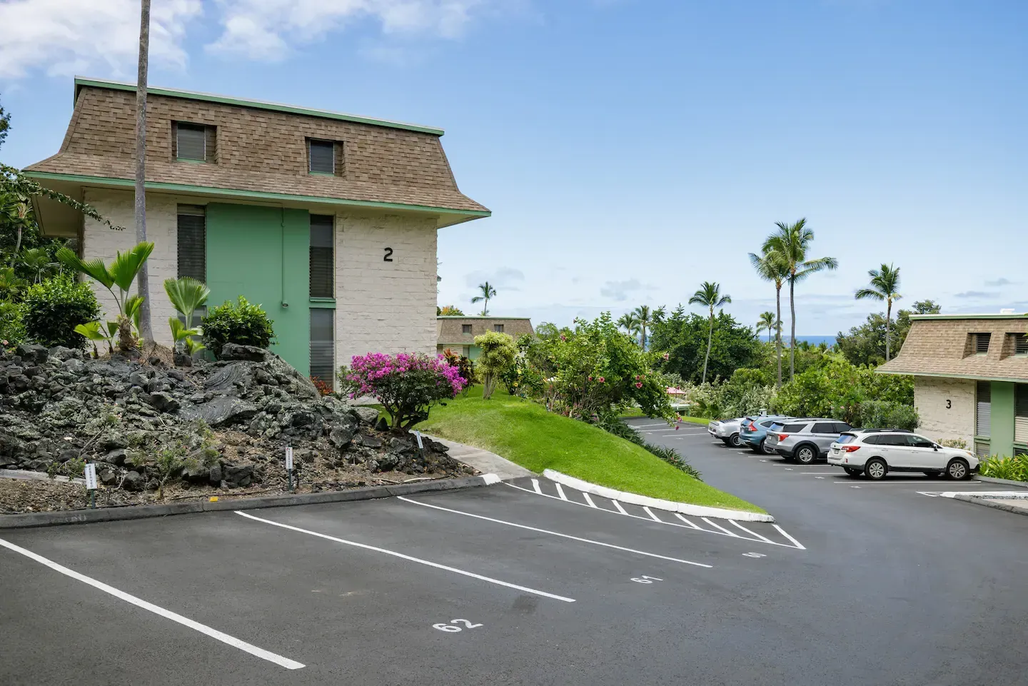 A parking lot with cars parked in front of a building