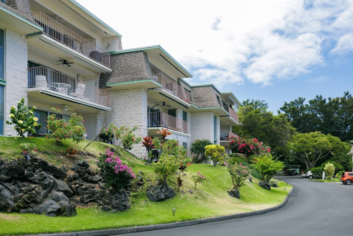 A row of houses are sitting on top of a grassy hill.