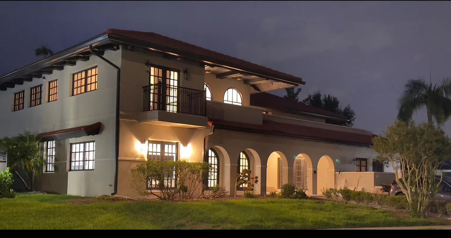 A large house with many windows is lit up at night