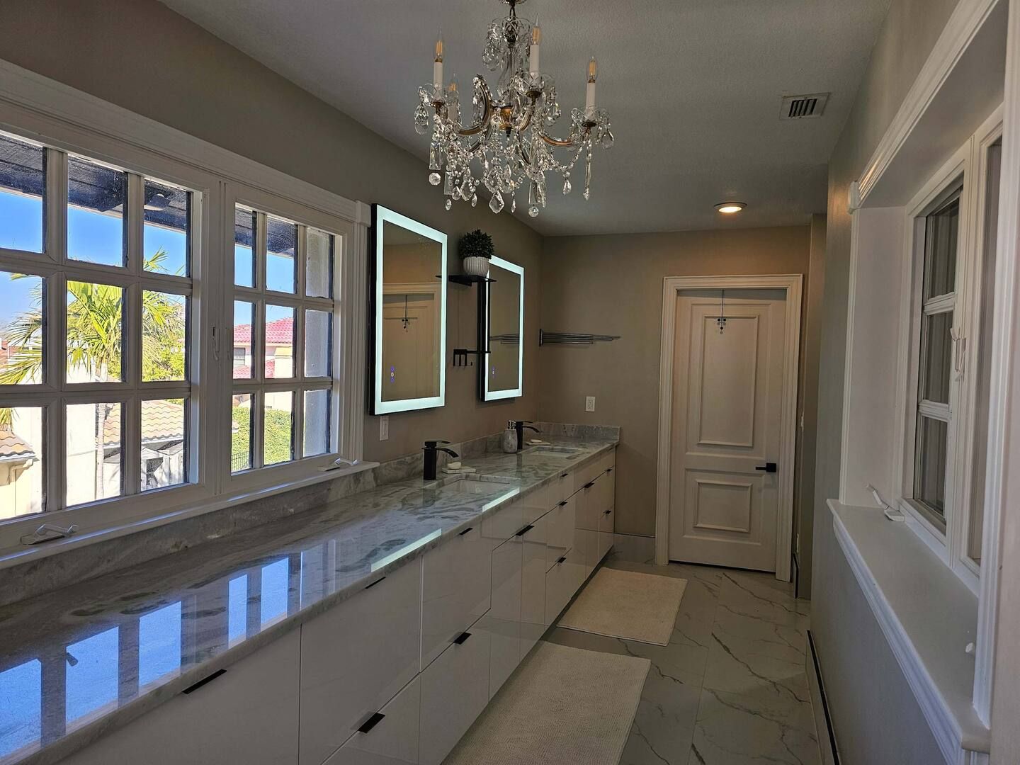 A bathroom with two sinks and a chandelier hanging from the ceiling.