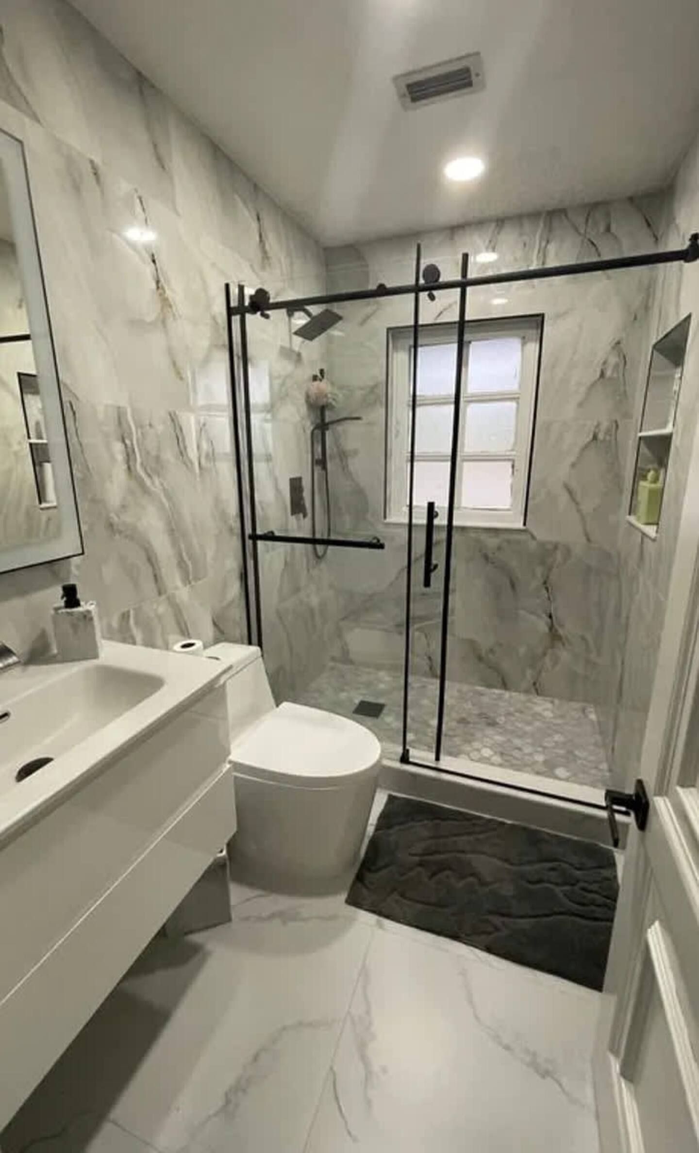 A bathroom with a toilet , sink , and shower stall.