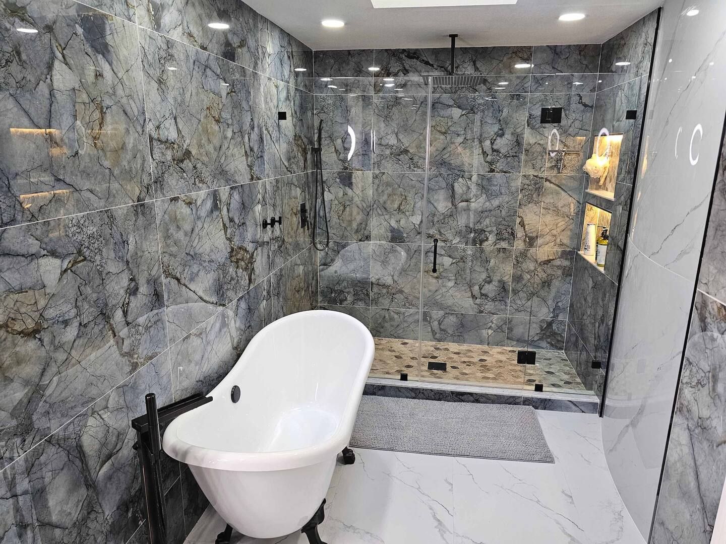 A bathroom with a bathtub and a walk in shower.