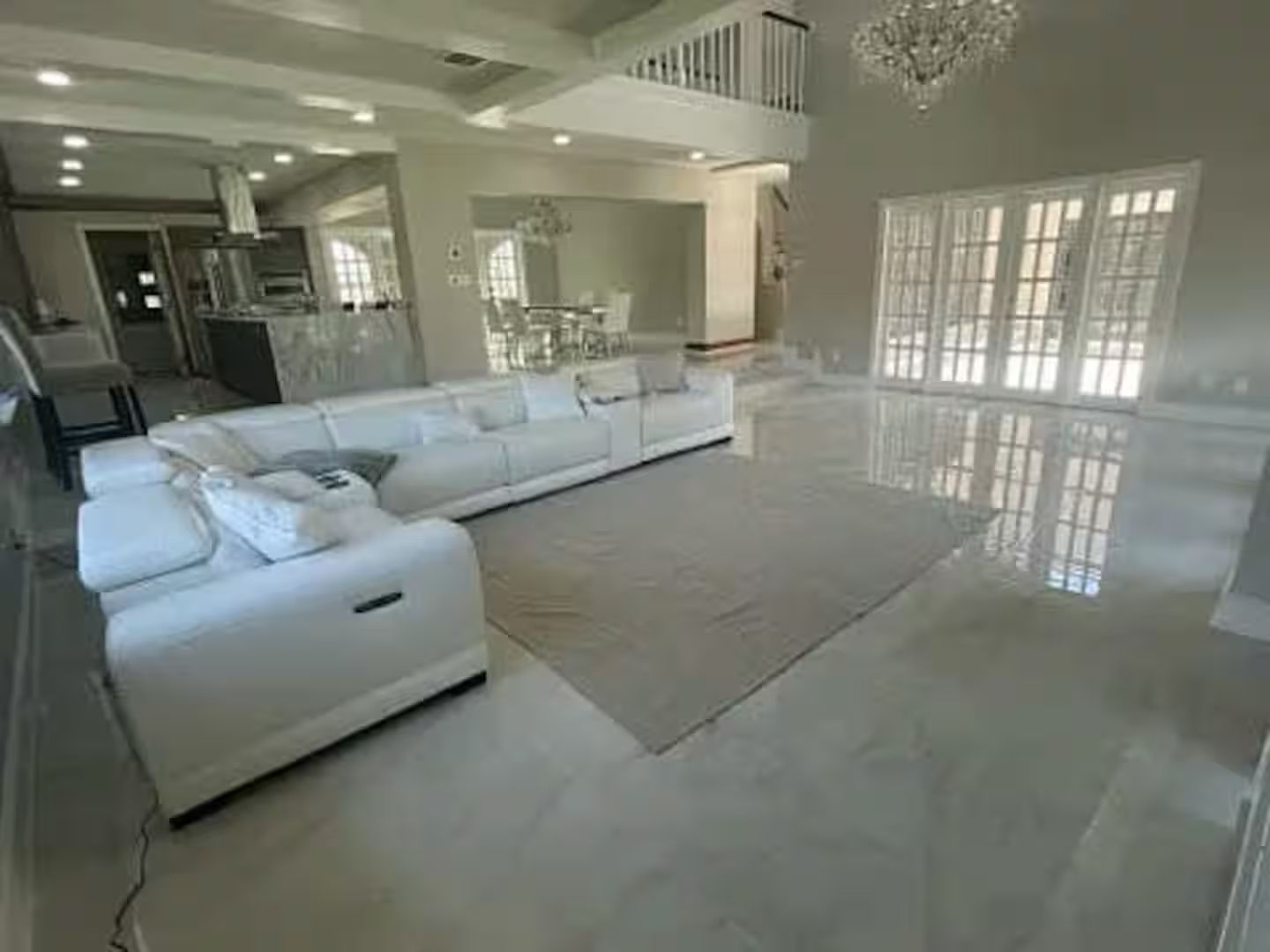 A living room with a white couch and a white rug.