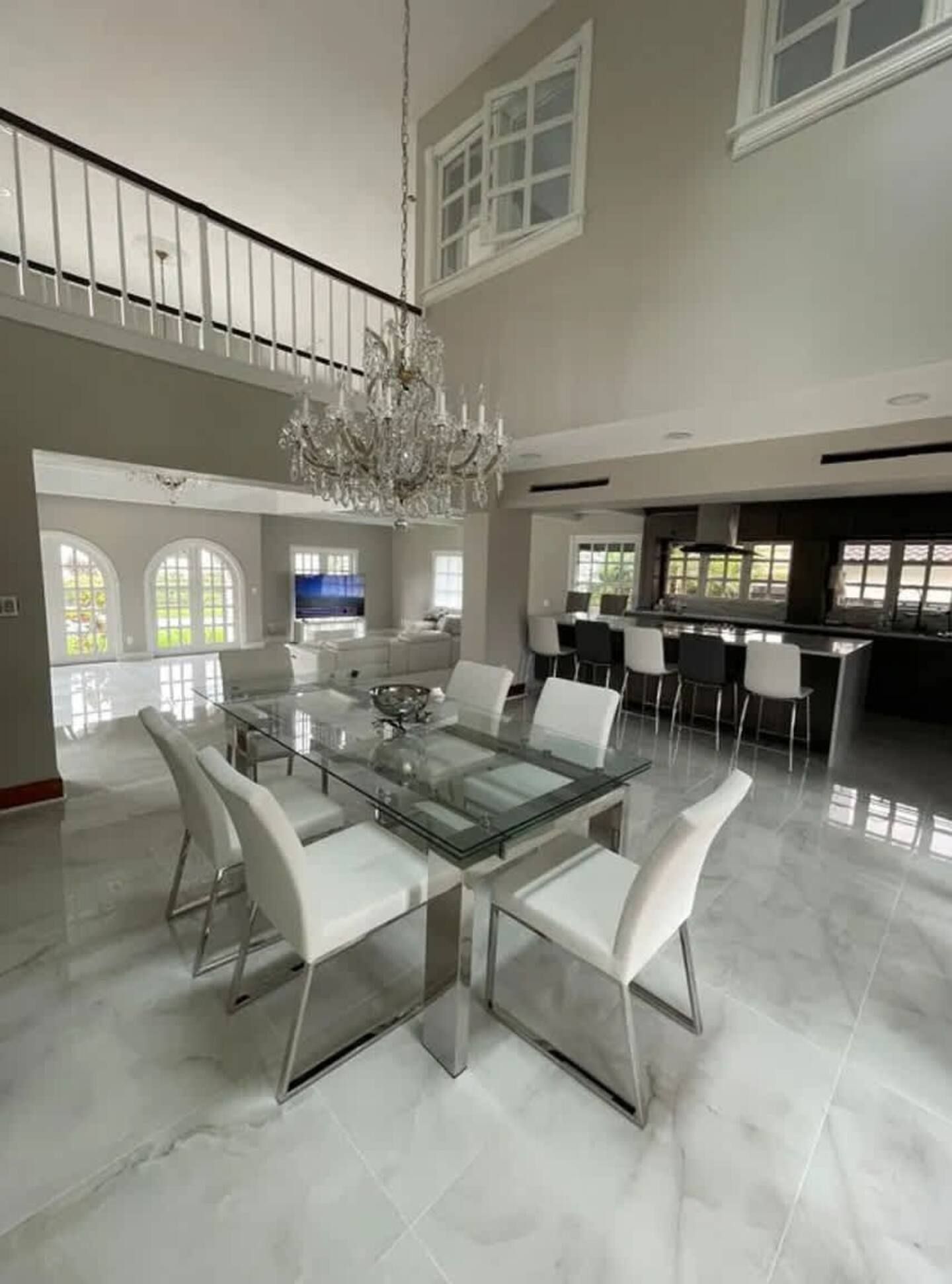 A dining room with a table and chairs and a chandelier hanging from the ceiling.