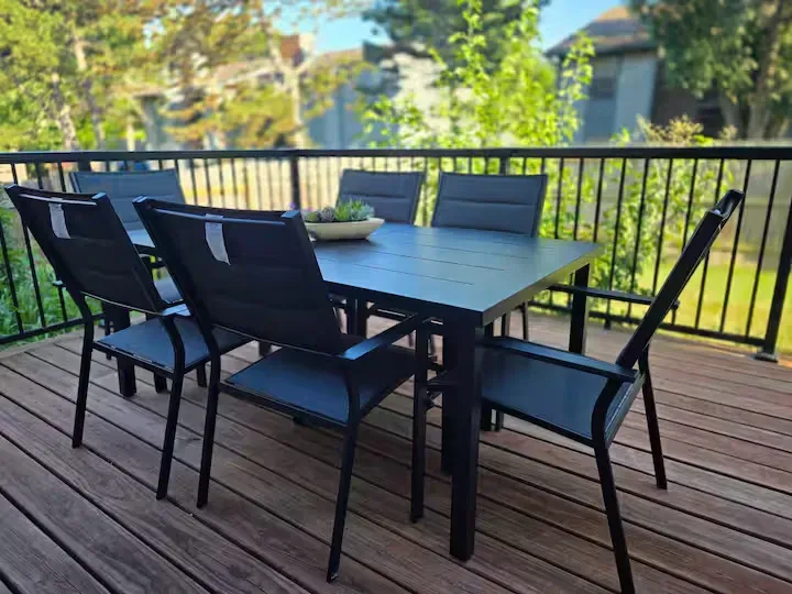 A wooden deck with a table and chairs on it.