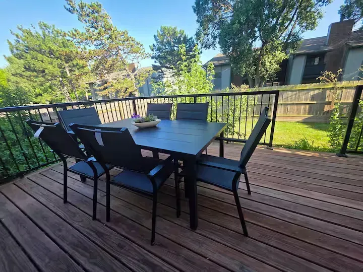A wooden deck with a table and chairs on it