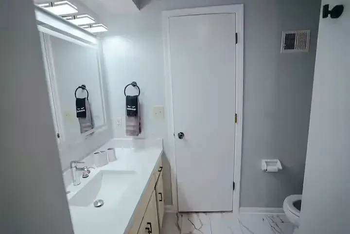 A bathroom with a sink , toilet and mirror.