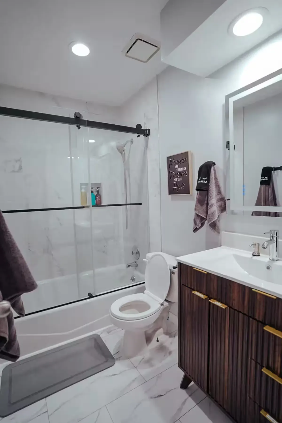 A bathroom with a toilet , sink , tub and shower.