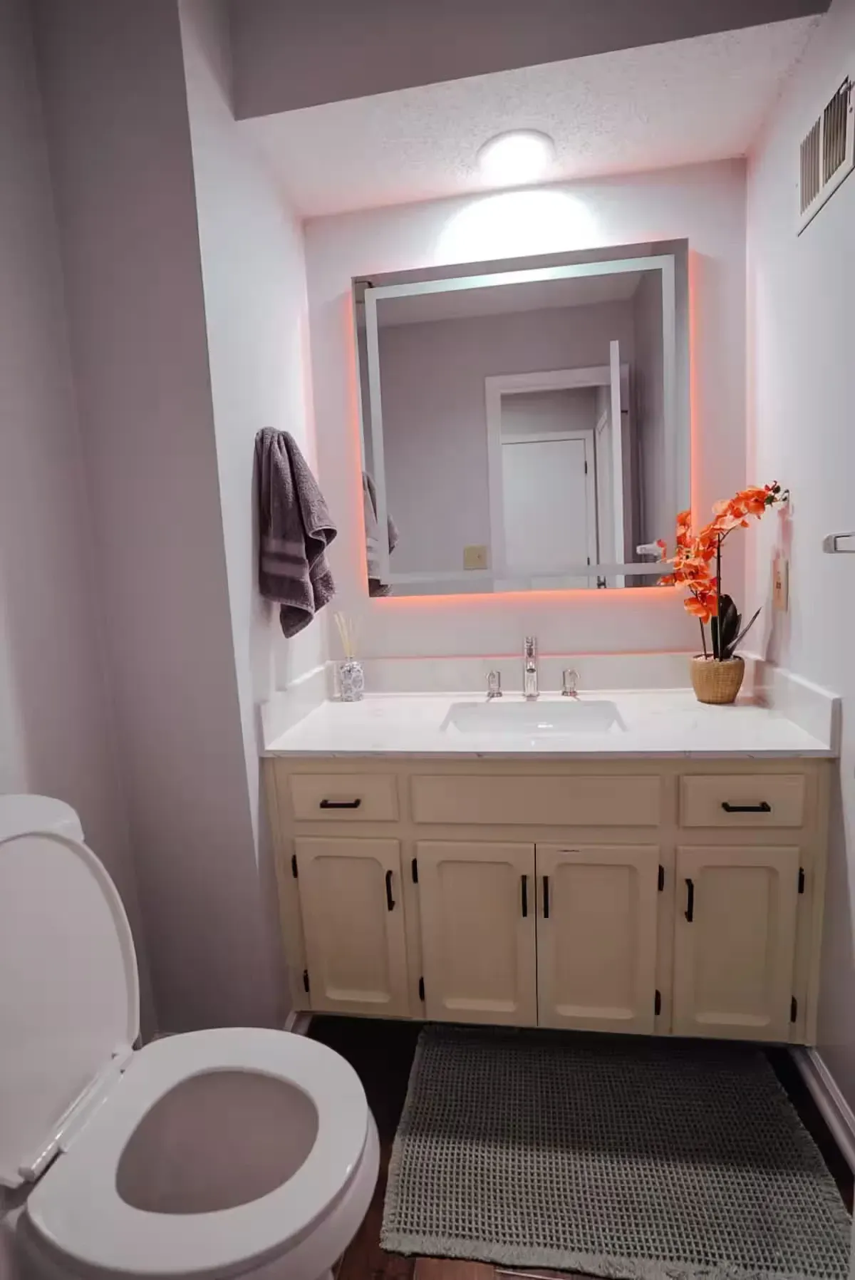 A bathroom with a toilet , sink and mirror