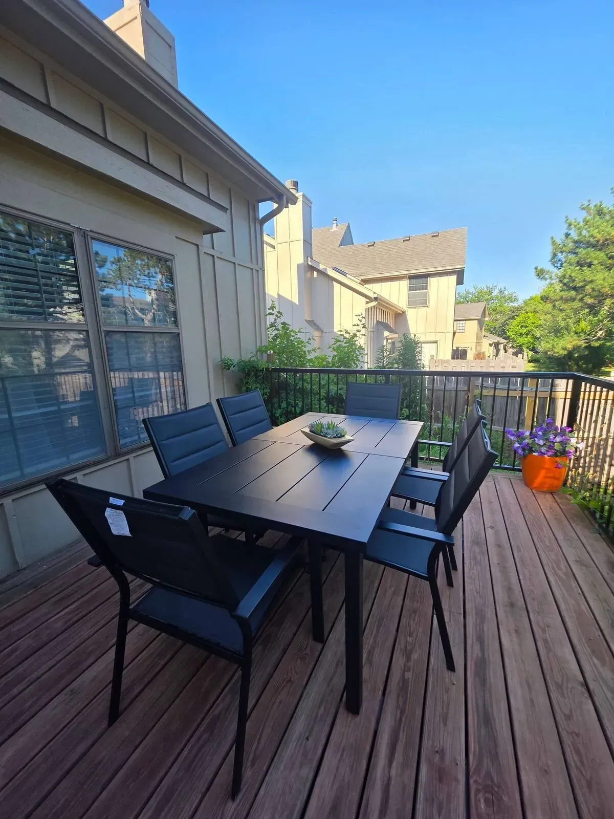 A wooden deck with a table and chairs on it.