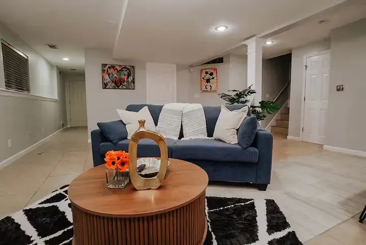 A living room with a blue couch and a wooden coffee table.