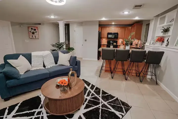 A living room with a couch , coffee table , chairs and a rug.