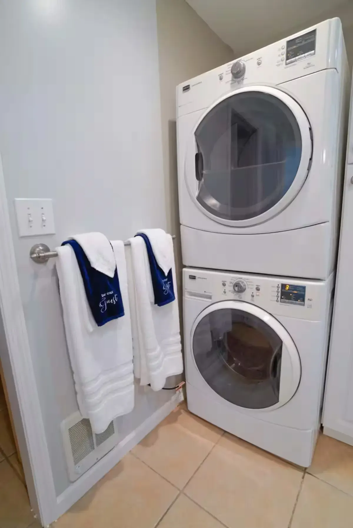 A washer and dryer are stacked on top of each other in a laundry room.