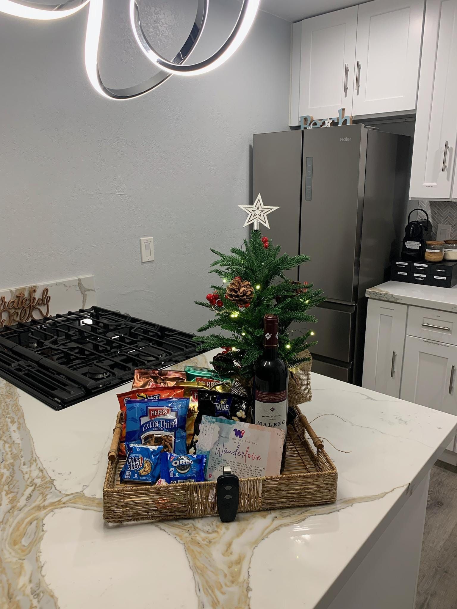 A christmas tree is sitting on top of a wicker basket on a kitchen counter.