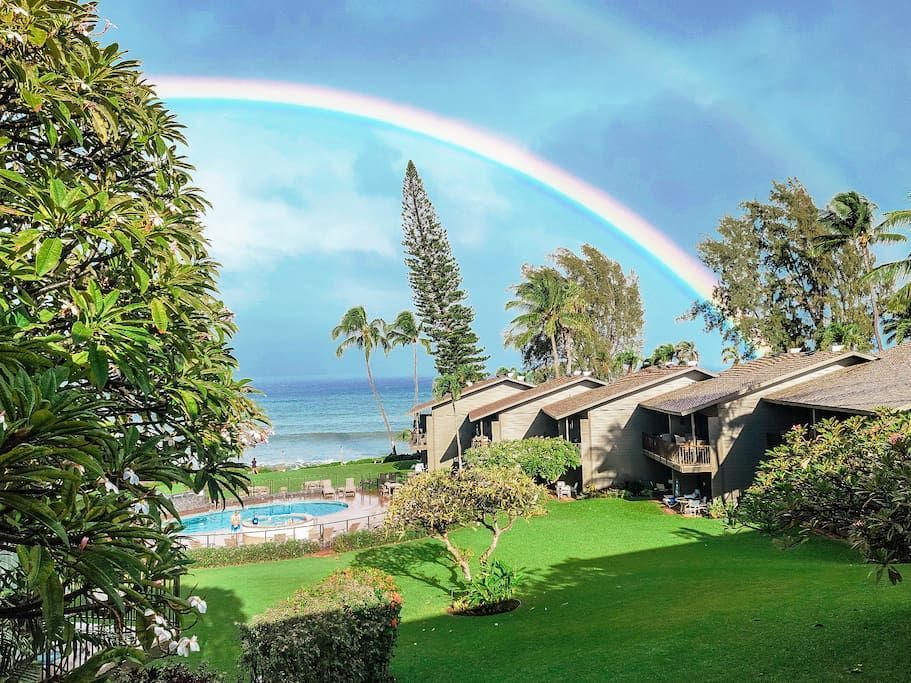 a rainbow is visible over a swimming pool