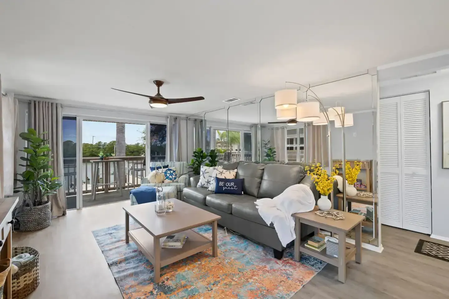 A living room with a couch , coffee table , and ceiling fan.