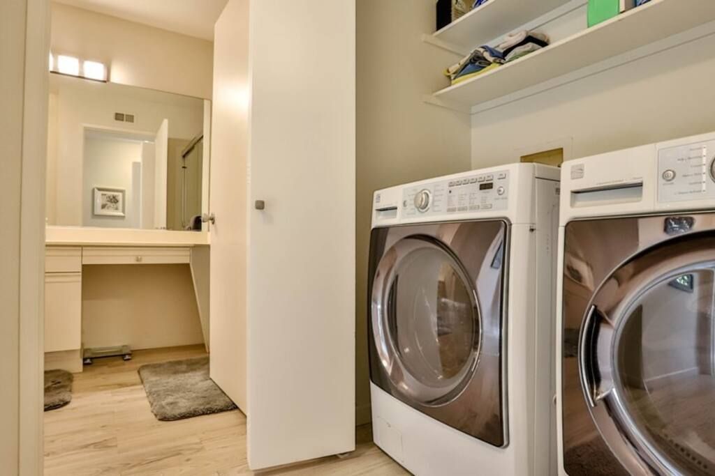 A washer and dryer are in a laundry room next to a bathroom.- California- Trip- Summer