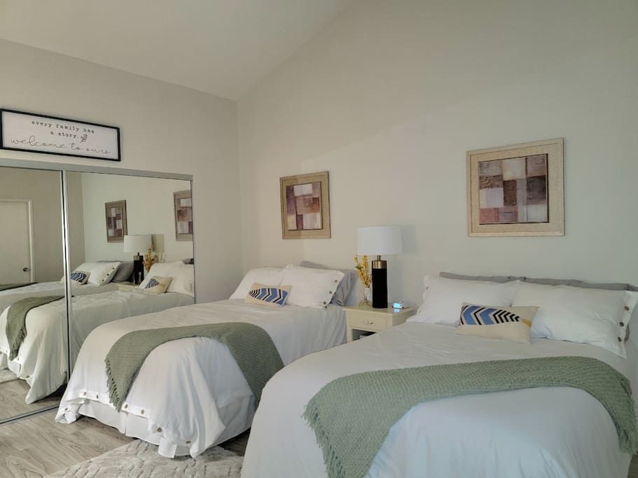 A bedroom with two beds and a large mirror- California- Trip- Summer
