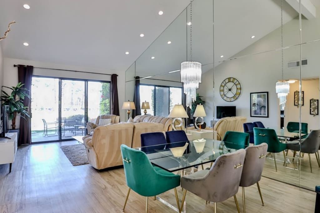 A living room with a dining table and chairs and a large mirror on the wall.- California- Trip- Summer